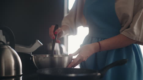 careful-wife-and-mother-is-frying-pancakes-for-breakfast-in-morning-woman-is-pouring-dough-in-pan
